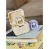 BIBS x LIBERTY Pacifier Box in Chloe Meadow - Ivory Mix and Oscar Meadow - Petal Mix, displayed on stacked books.