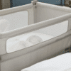 Shnuggle Air Lite Bedside Crib in grey and taupe, featuring breathable mesh sides and a cozy sleeping space for infants.
