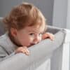 Shnuggle Air Cot Conversion Kit in Dove Grey, featuring a child playfully leaning over the edge of the cot.