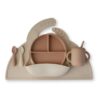 Mushie Stage 2 Feeding bundle in neutral tones, featuring a divided plate, cup, and utensils on a silicone mat.