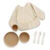 Mushie Stage 3 Feeding Bundle in beige includes a bib, bowl, plate, cup, fork, and knife. Perfect for toddlers.