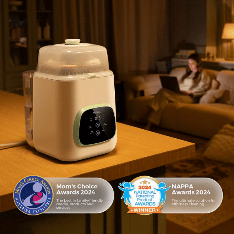 Momcozy KleanPal Pro Baby Bottle Washer, sterilizer, and dryer on a table, with a woman relaxing in the background.