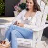 Momcozy Breast Pump S12 Pro in use, worn discreetly under a light cardigan, while a woman relaxes in an outdoor setting.