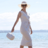 Momcozy Breast Pump Bag in white, stylishly carried by a woman in a beach setting, perfect for hands-free pumping.
