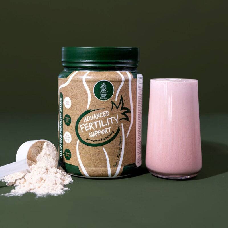 SoFitt™ Advanced Fertility Support powder beside a pink smoothie in a glass, with a scoop and powder on a green background.
