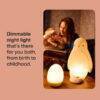 Tommee Tippee Penguin Night Light in a cozy setting, illuminating a mother reading to her child, showcasing its dimmable