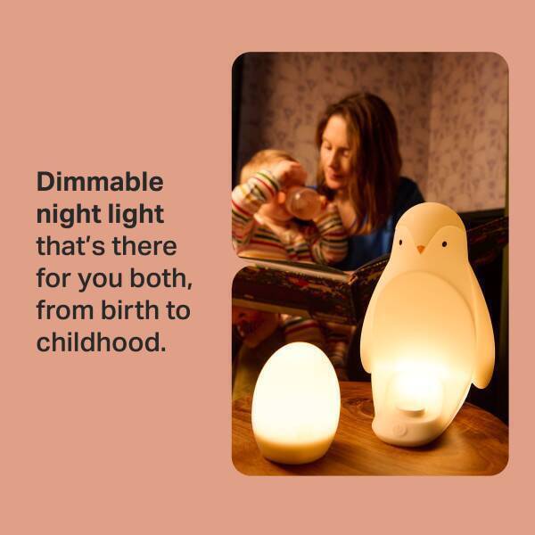 Tommee Tippee Penguin Night Light in a cozy setting, illuminating a mother reading to her child, showcasing its dimmable