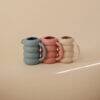 Mushie Silicone Watering Can set in French Blue, Peony, and a speckled design, showcasing a playful, modern aesthetic.