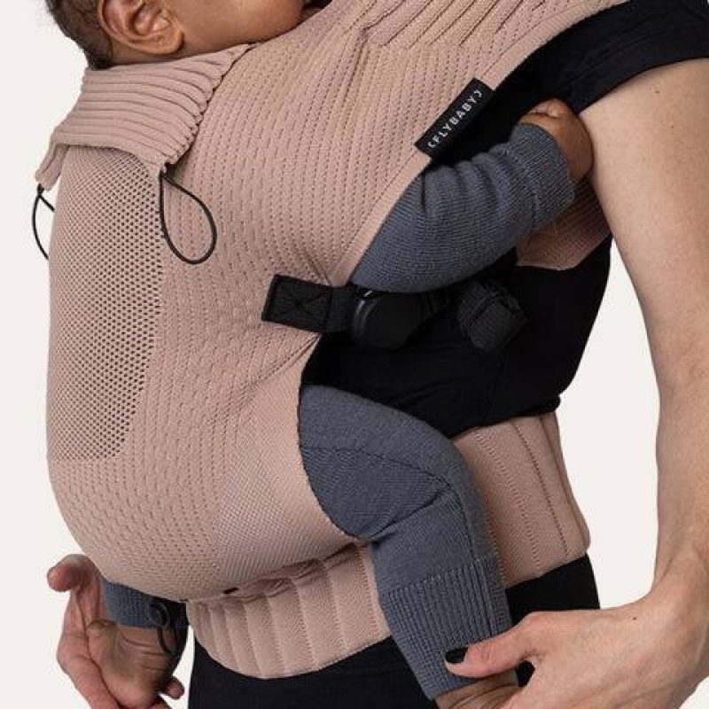 FlyBaby Baby Carrier in beige with textured knit design, securely holding a baby against the wearer's chest.